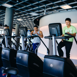 two men in gym on stair steppers