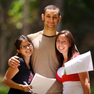 two women and one man smiling for camera on campus